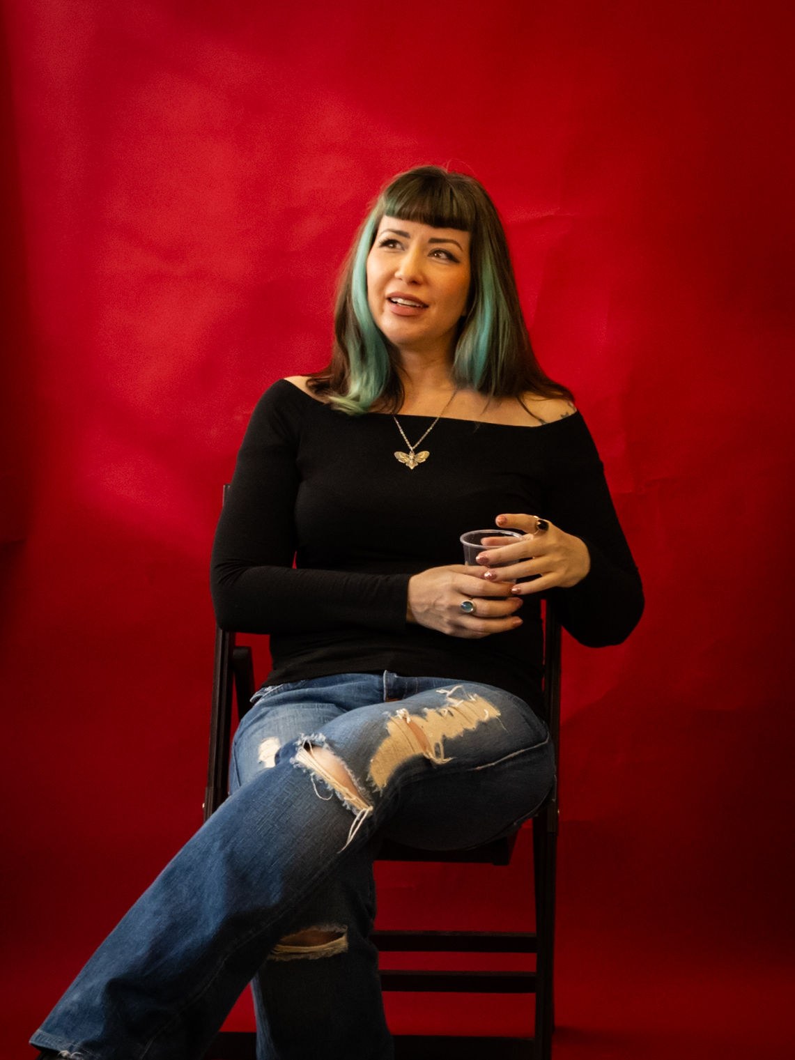 Leah Jane Hendrix seated in the red glow of a recording studio